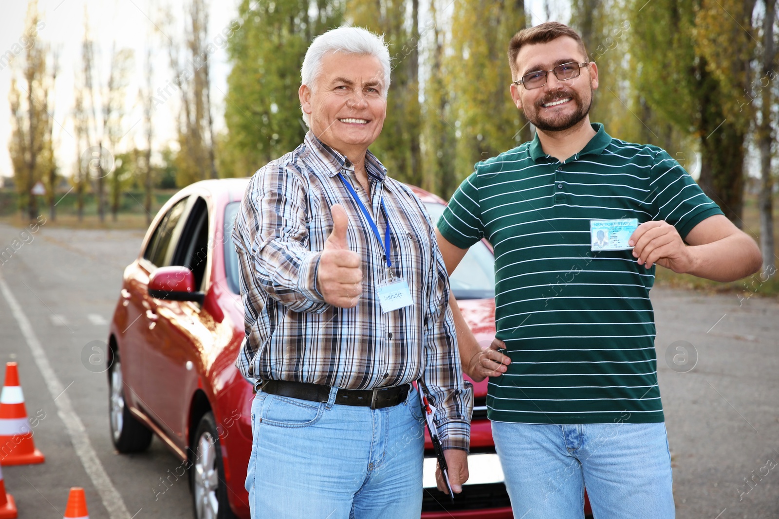 Photo of Senior instructor and happy man with driving license outdoors