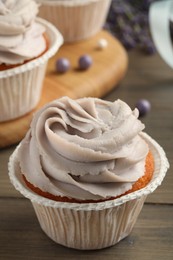 Photo of Tasty cupcake with cream on table, closeup view