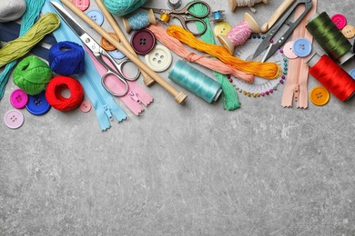 Photo of Composition with threads and sewing accessories on grey background