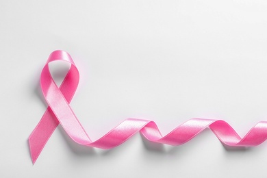 Photo of Pink ribbon on white background, top view. Cancer awareness