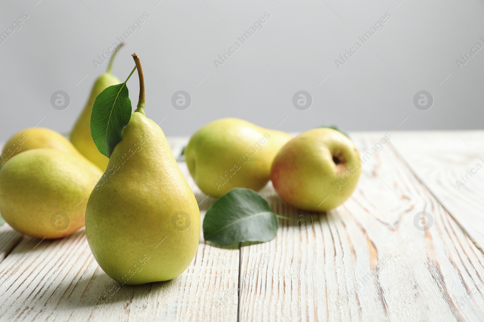 Photo of Ripe pears on wooden table. Space for text