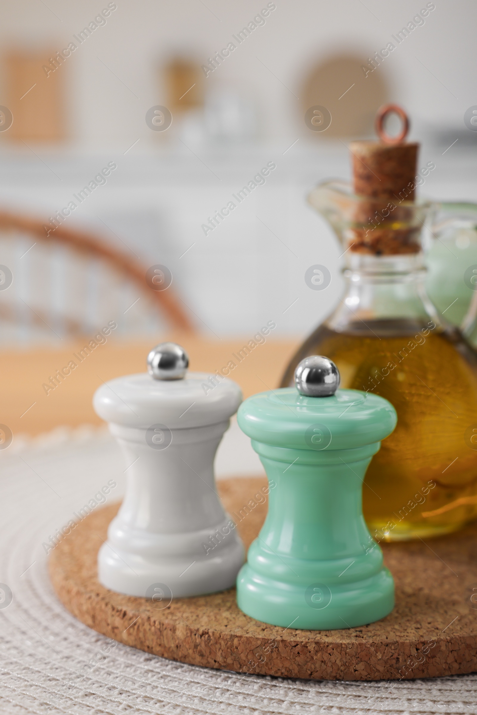 Photo of Salt and pepper shakers and bottle of oil on table in kitchen