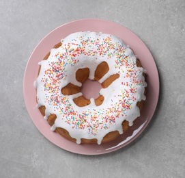 Glazed Easter cake with sprinkles on grey table, top view