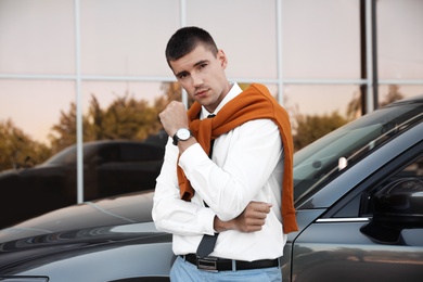 Attractive young man near luxury car outdoors