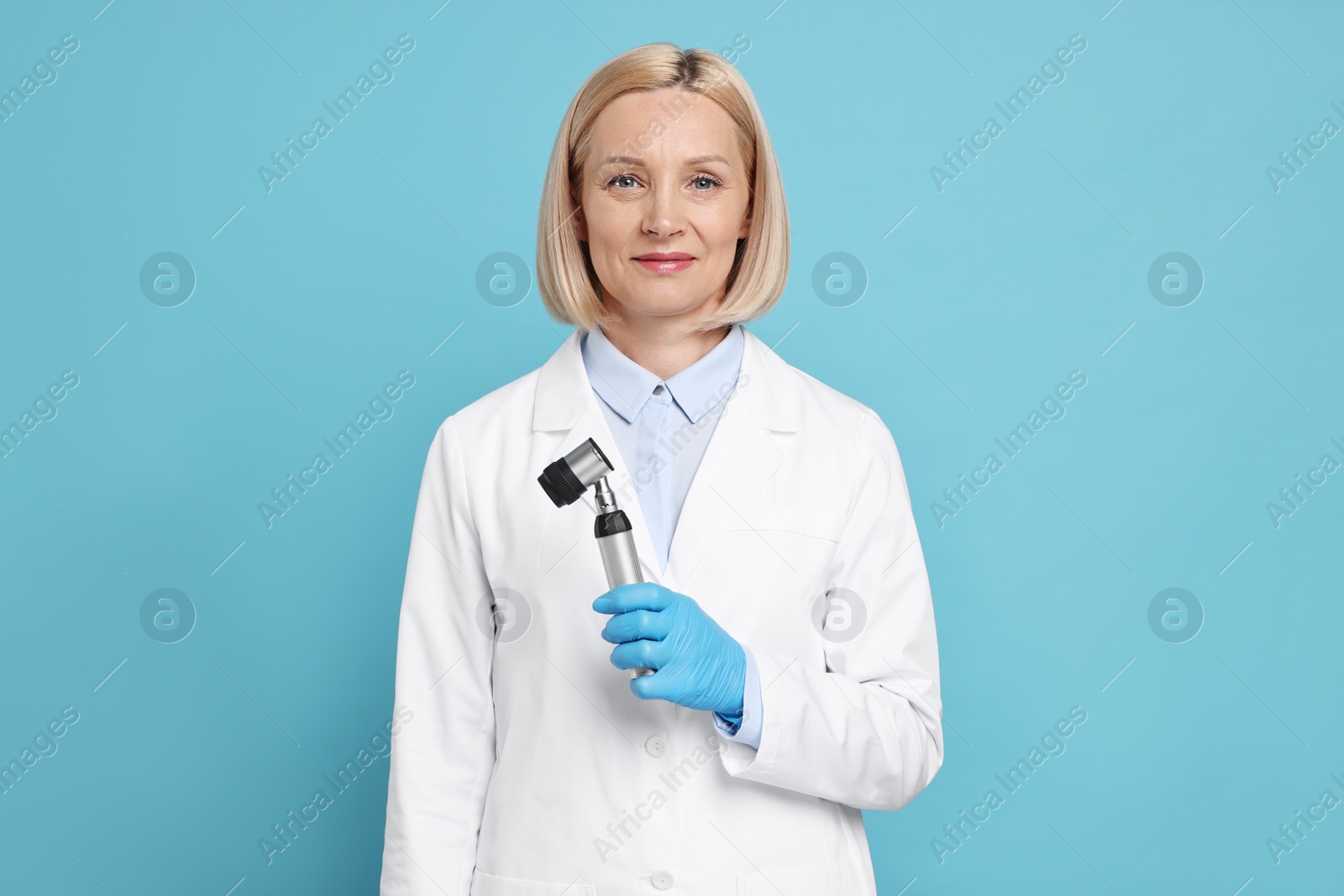 Photo of Dermatologist with dermatoscope on light blue background