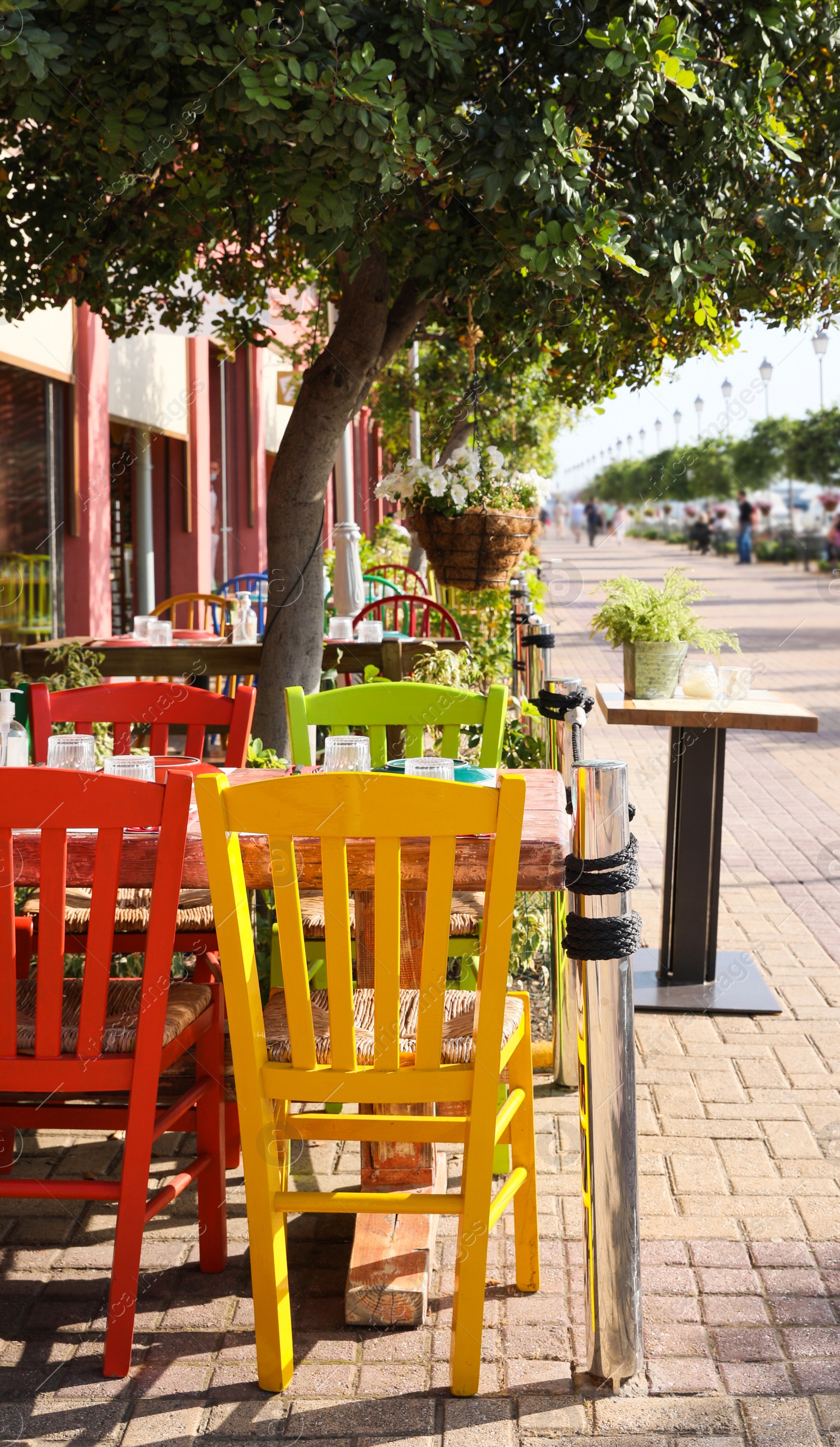 Photo of Beautiful view of outdoor cafe with colorful wooden chairs