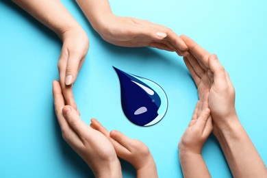 Image of Parents and child protecting paper water drop on light blue background, top view