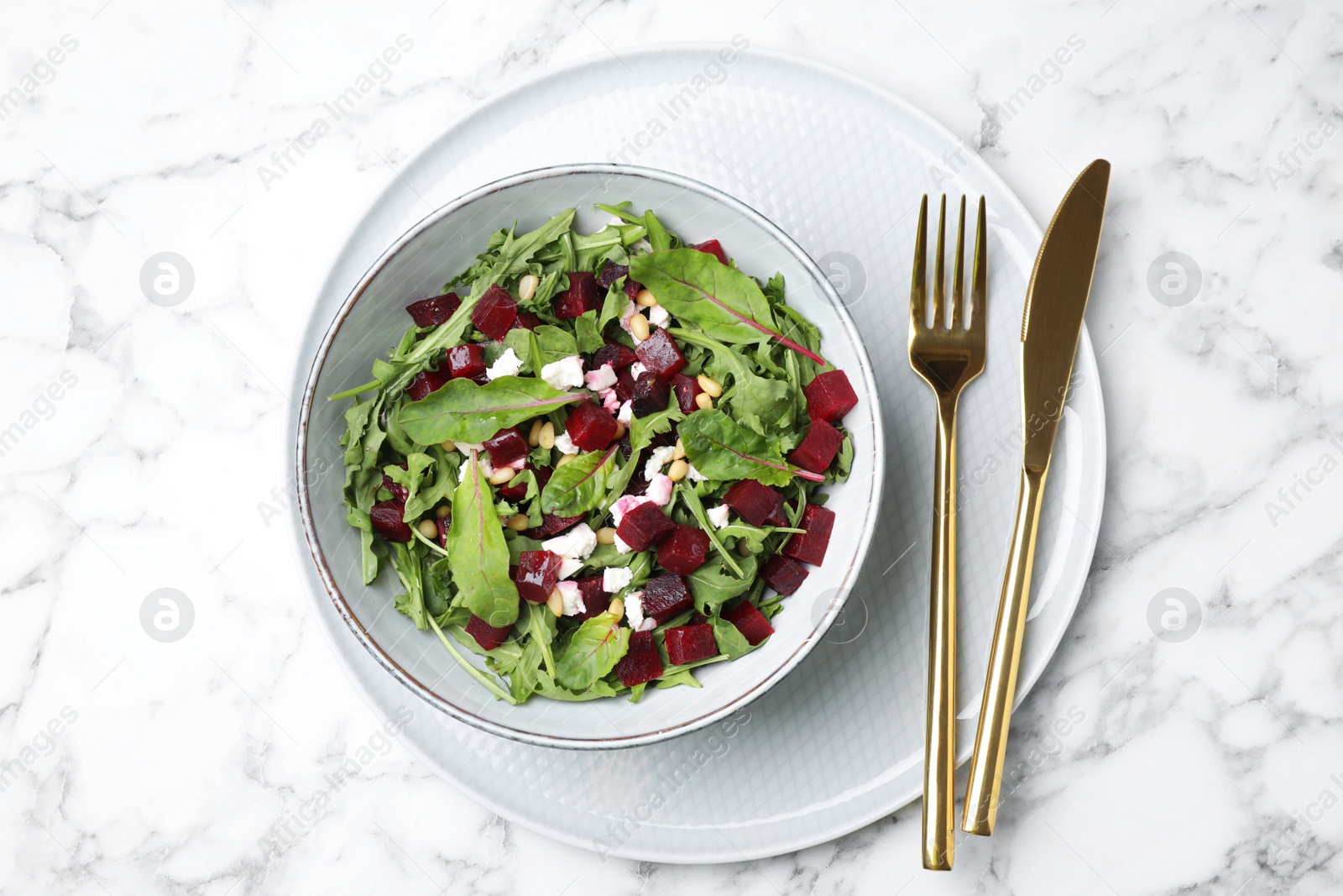 Photo of Delicious beet salad served on white marble table, top view