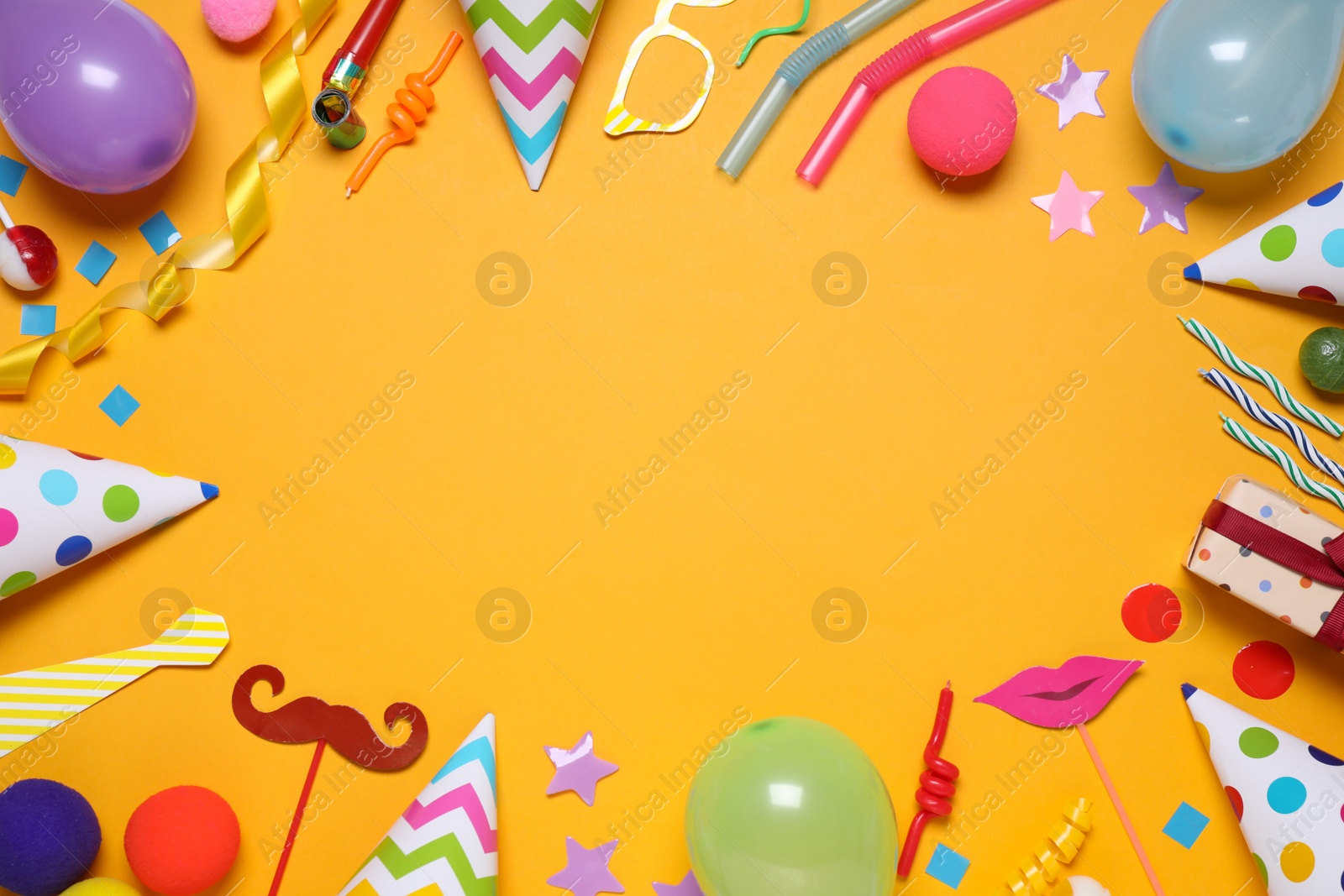 Photo of Frame of different party items and decorations with space for text on orange background, flat lay