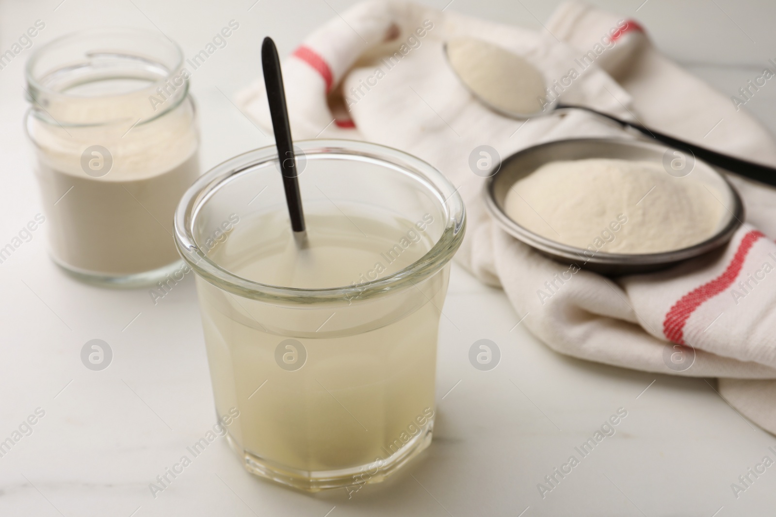 Photo of Agar-agar jelly and powder on white marble table