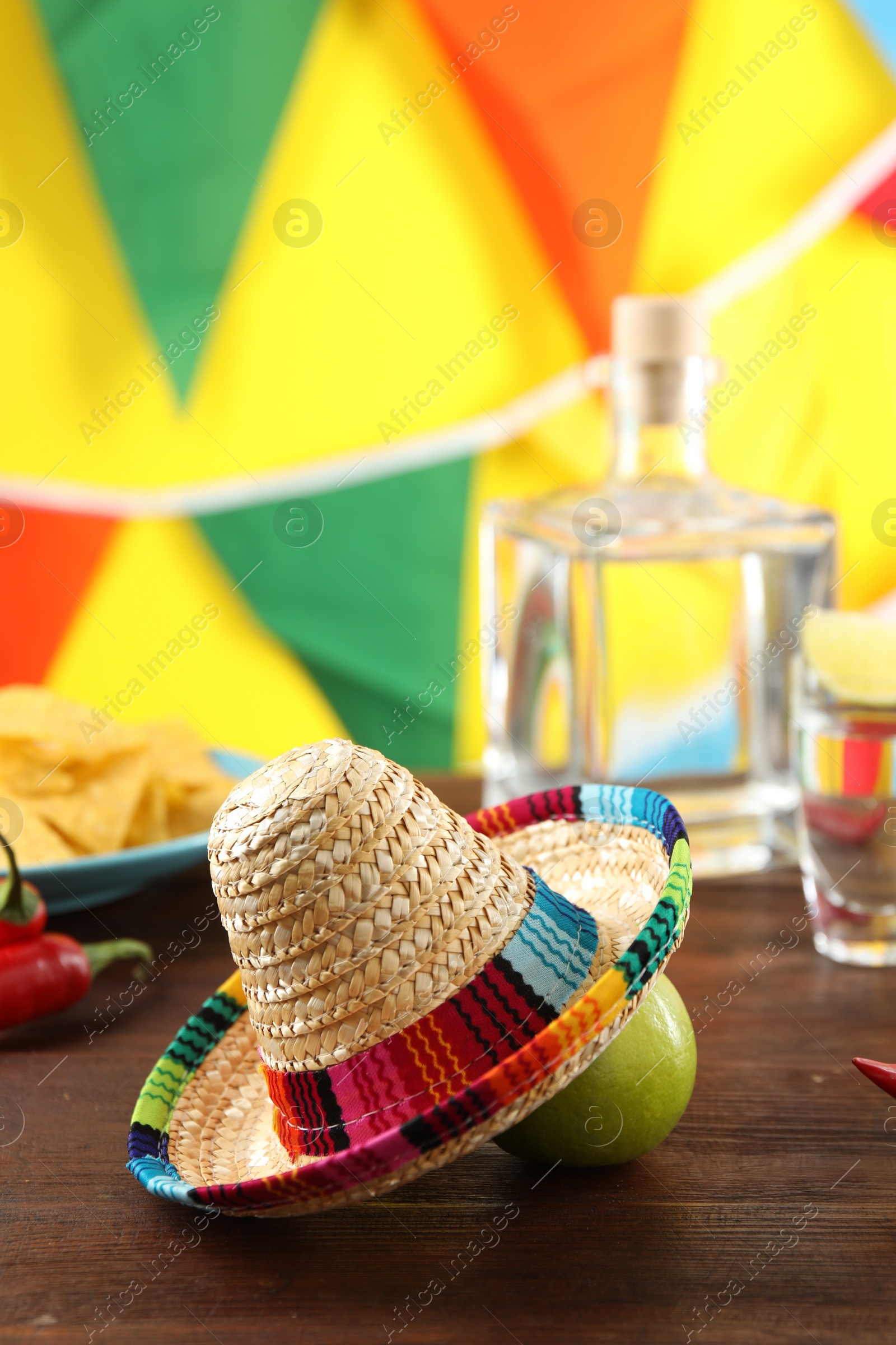 Photo of Mexican sombrero hat and lime on wooden table