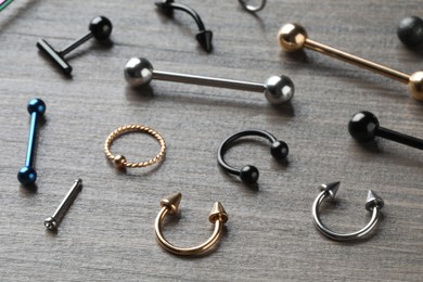 Photo of Stylish jewelry for piercing on wooden table