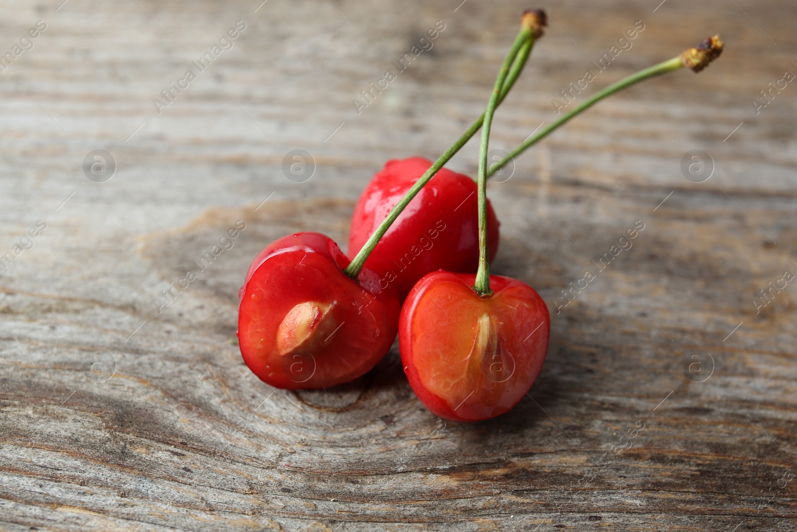 Photo of Ripe red cherries with water drops on wooden background