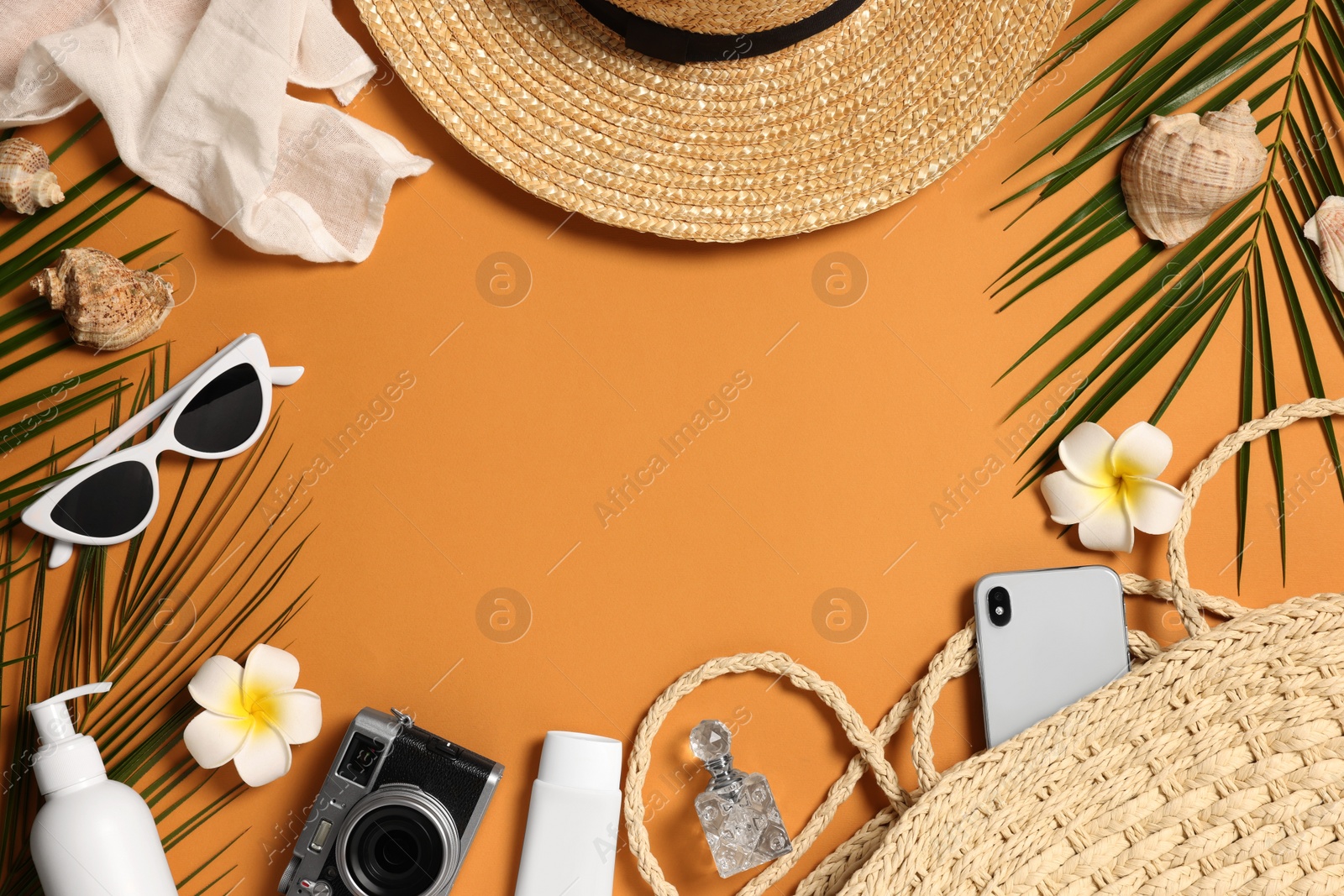 Photo of Flat lay composition with wicker bag and other beach accessories on orange background. Space for text