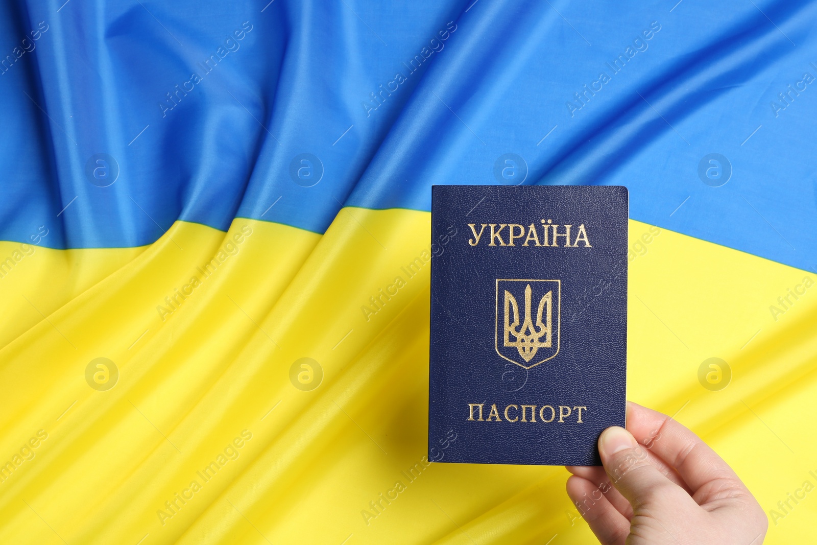 Photo of Woman holding Ukrainian internal passport on national flag, closeup. Space for text