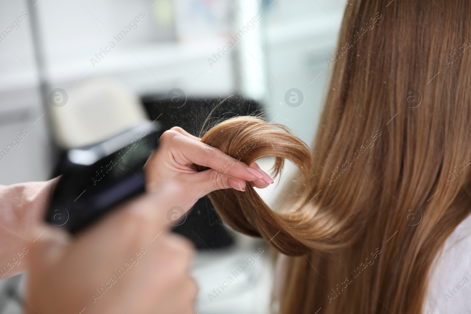 Photo of Professional hairdresser working with client in beauty salon, closeup