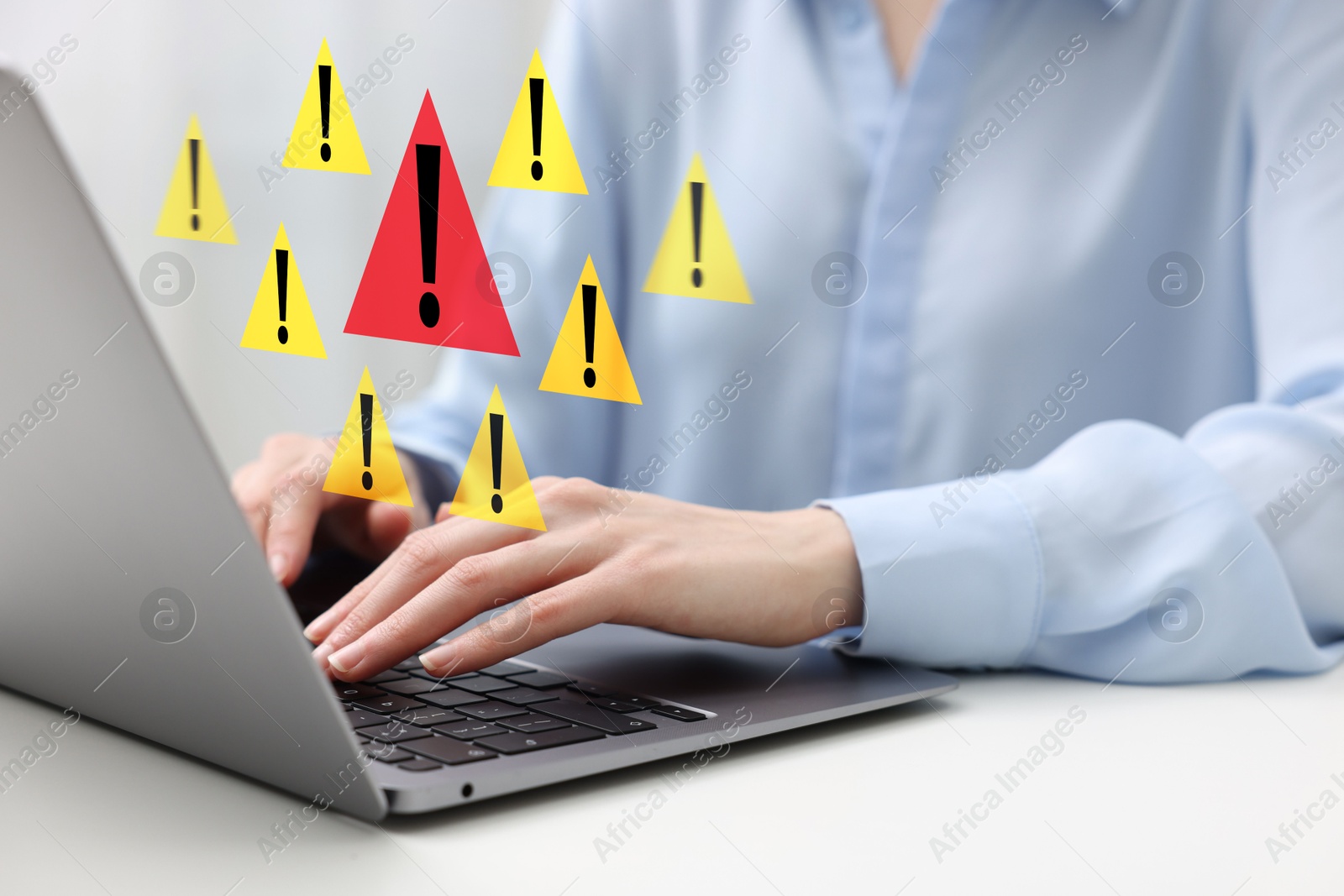 Image of Woman using laptop at table, closeup. Warning signs for spam messages above device