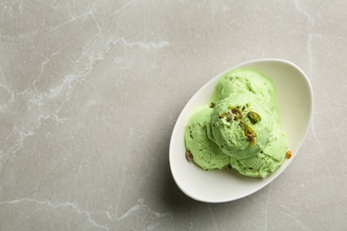 Photo of Tasty pistachio ice cream on grey table, top view. Space for text