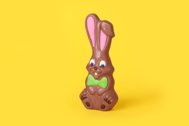Photo of Chocolate bunny on yellow background. Easter celebration