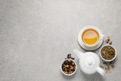 Photo of Fresh brewed tea and dry leaves on light grey background, flat lay. Space for text