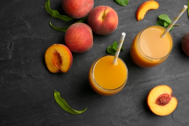Photo of Natural freshly made peach juice on grey table, flat lay