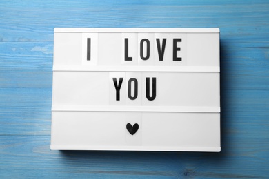 Lightbox with phrase I Love You on blue wooden background, top view