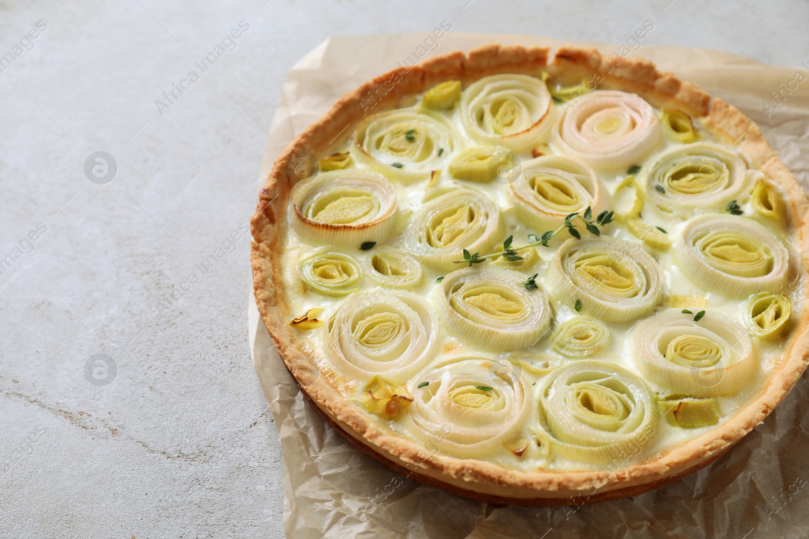 Tasty leek pie on grey textured table, closeup. Space for text Photo of Tasty leek pie on grey textured table, closeup. Space for text