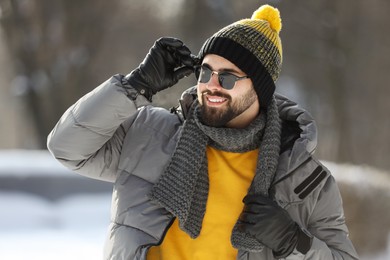 Portrait of handsome young man with sunglasses on winter day outdoors