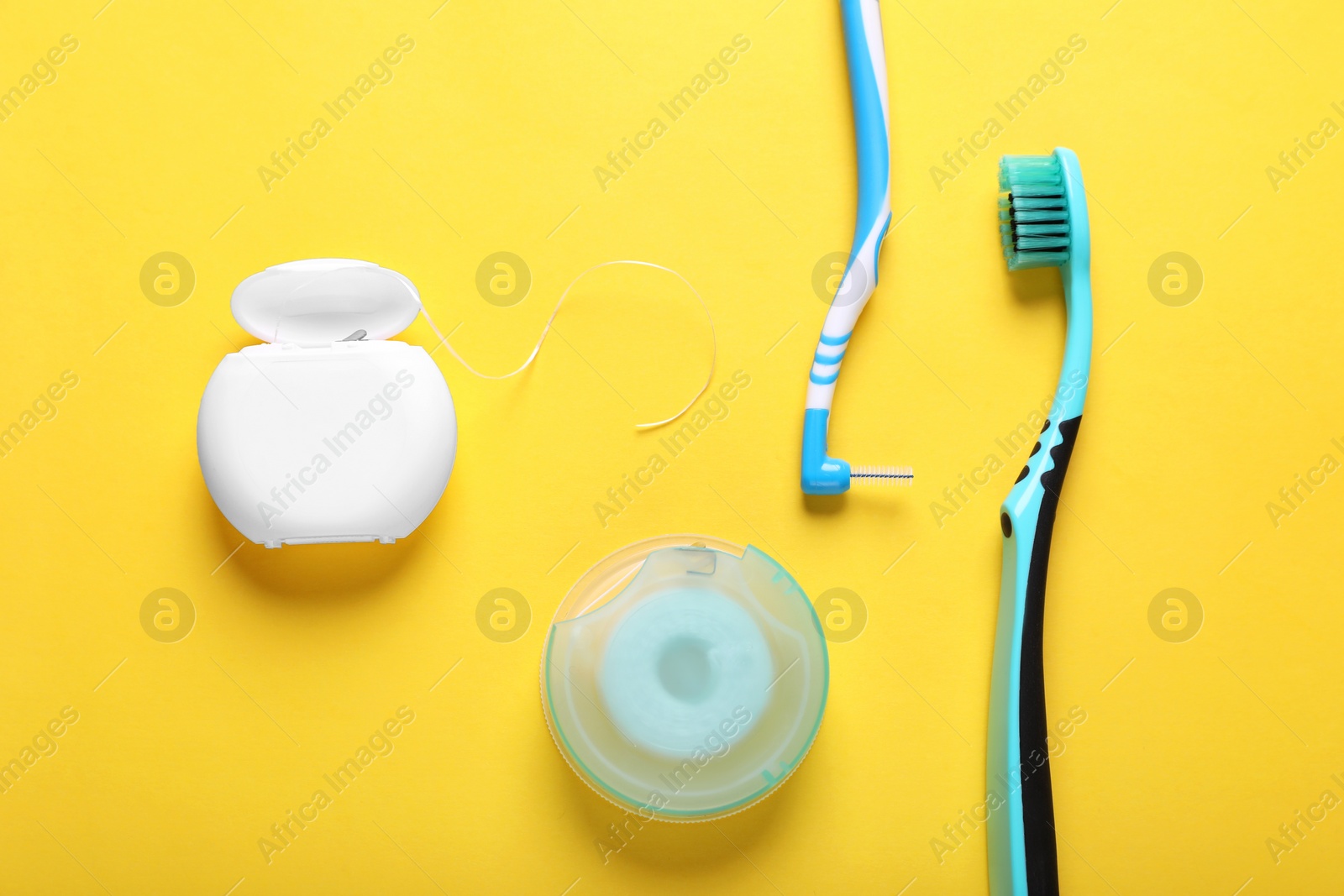 Photo of Flat lay composition with dental floss and different teeth care products on yellow background