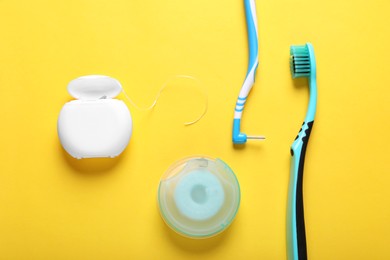 Flat lay composition with dental floss and different teeth care products on yellow background