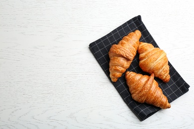 Photo of Tasty croissants and space for text on white wooden background, top view. French pastry