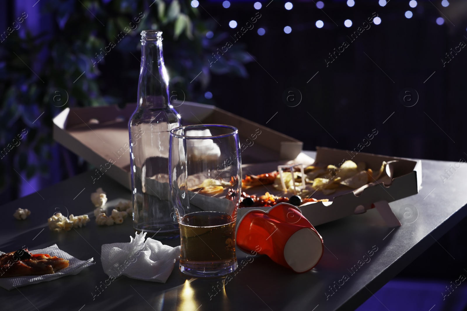 Photo of Messy table with beer and food leftovers indoors. After party chaos