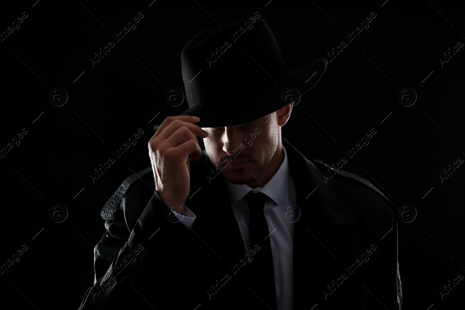 Photo of Old fashioned detective in hat on dark background