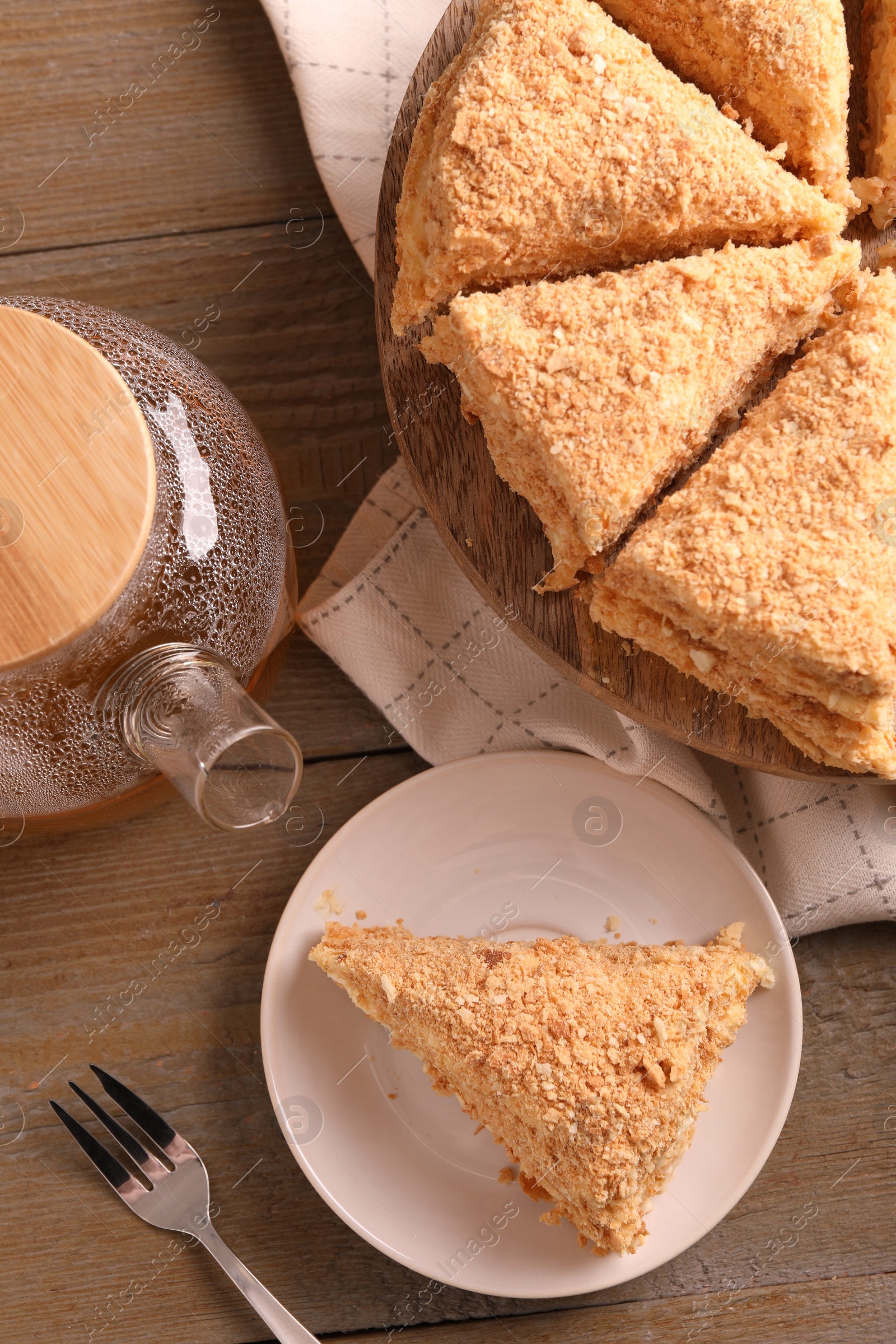 Photo of Delicious Napoleon cake served on wooden table, flat lay