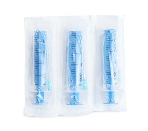 Packed disposable syringes with needles on white background, top view