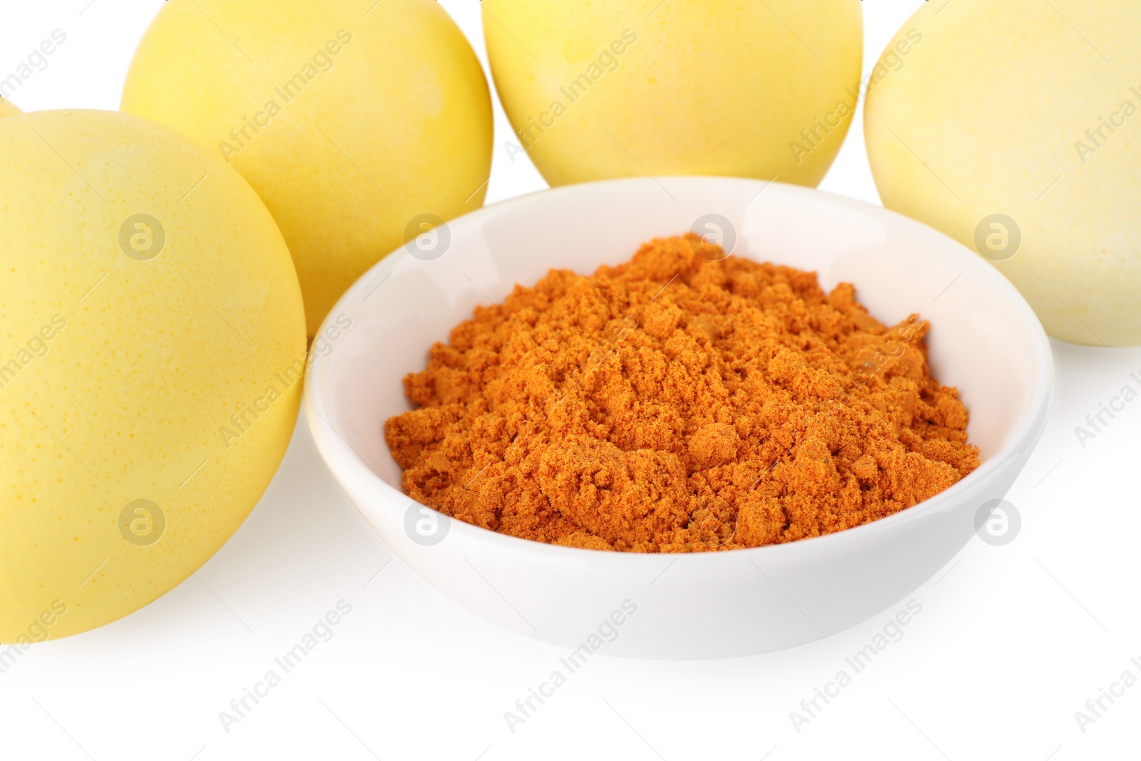 Photo of Yellow Easter eggs painted with natural dye and turmeric powder in bowl on white background