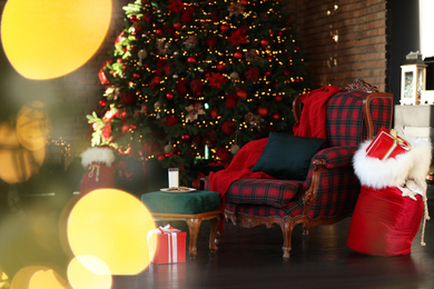 Santa Claus bag near armchair in room with Christmas tree