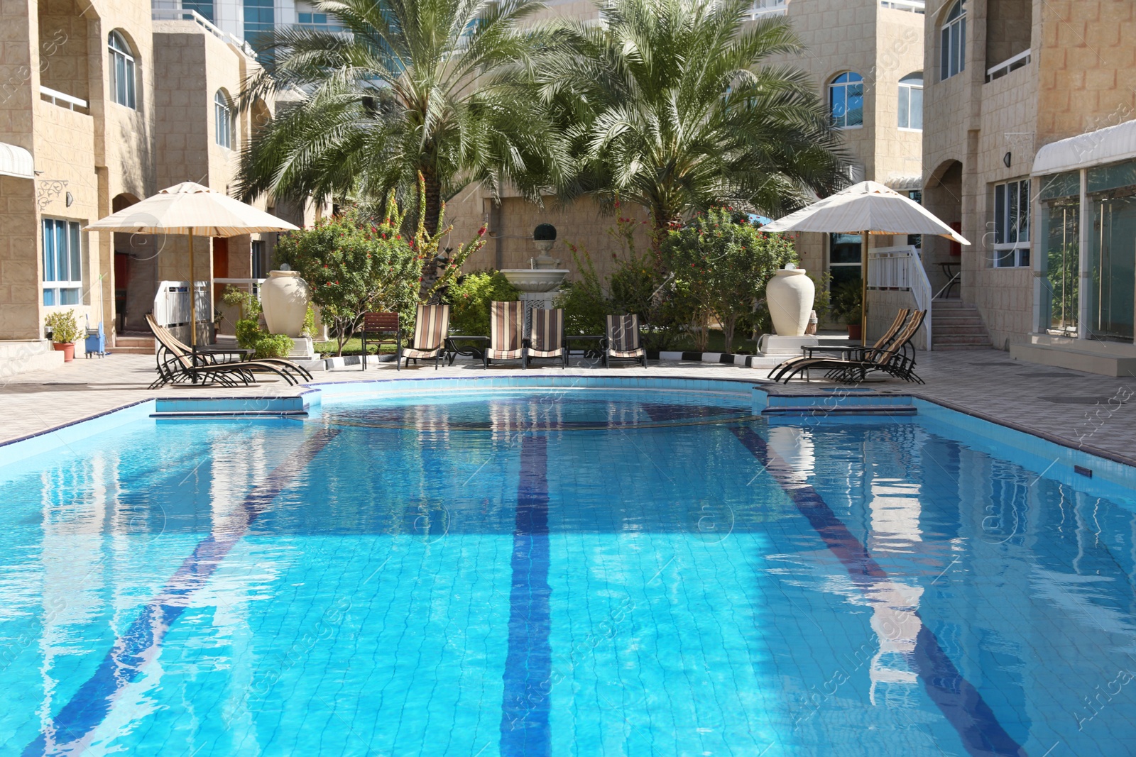 Photo of Modern luxury hotel with swimming pool on sunny day