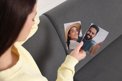 Photo of Woman holding torn photo on sofa, closeup. Divorce concept