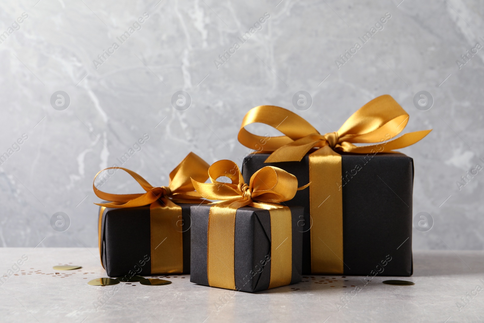 Photo of Beautifully wrapped gift boxes and confetti on white table