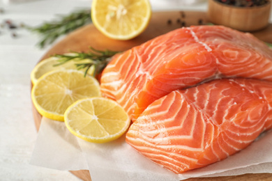 Photo of Fresh raw salmon with lemon on table. Fish delicacy