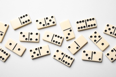 Classic domino tiles on white background, flat lay