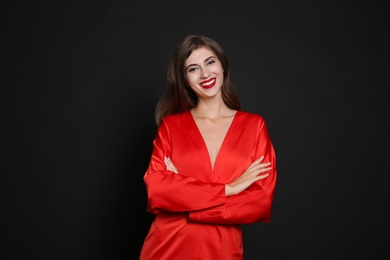 Photo of Happy woman in red dress on black background. Christmas party