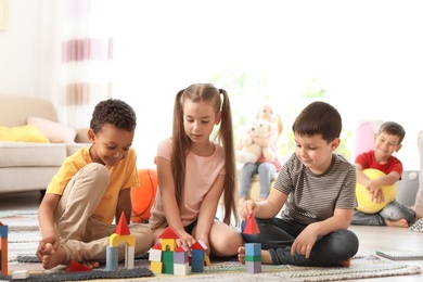 Photo of Cute little children playing together indoors