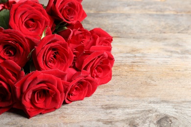 Photo of Beautiful red rose flowers on wooden background