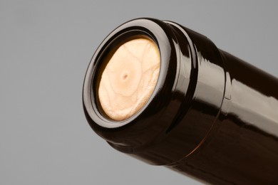 Wine bottle with cork on grey background, closeup. Space for text