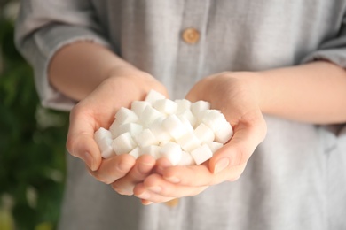 Woman holding sugar cubes, closeup