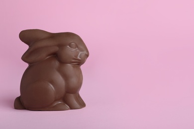 Photo of Chocolate bunny on pink background, space for text. Easter celebration