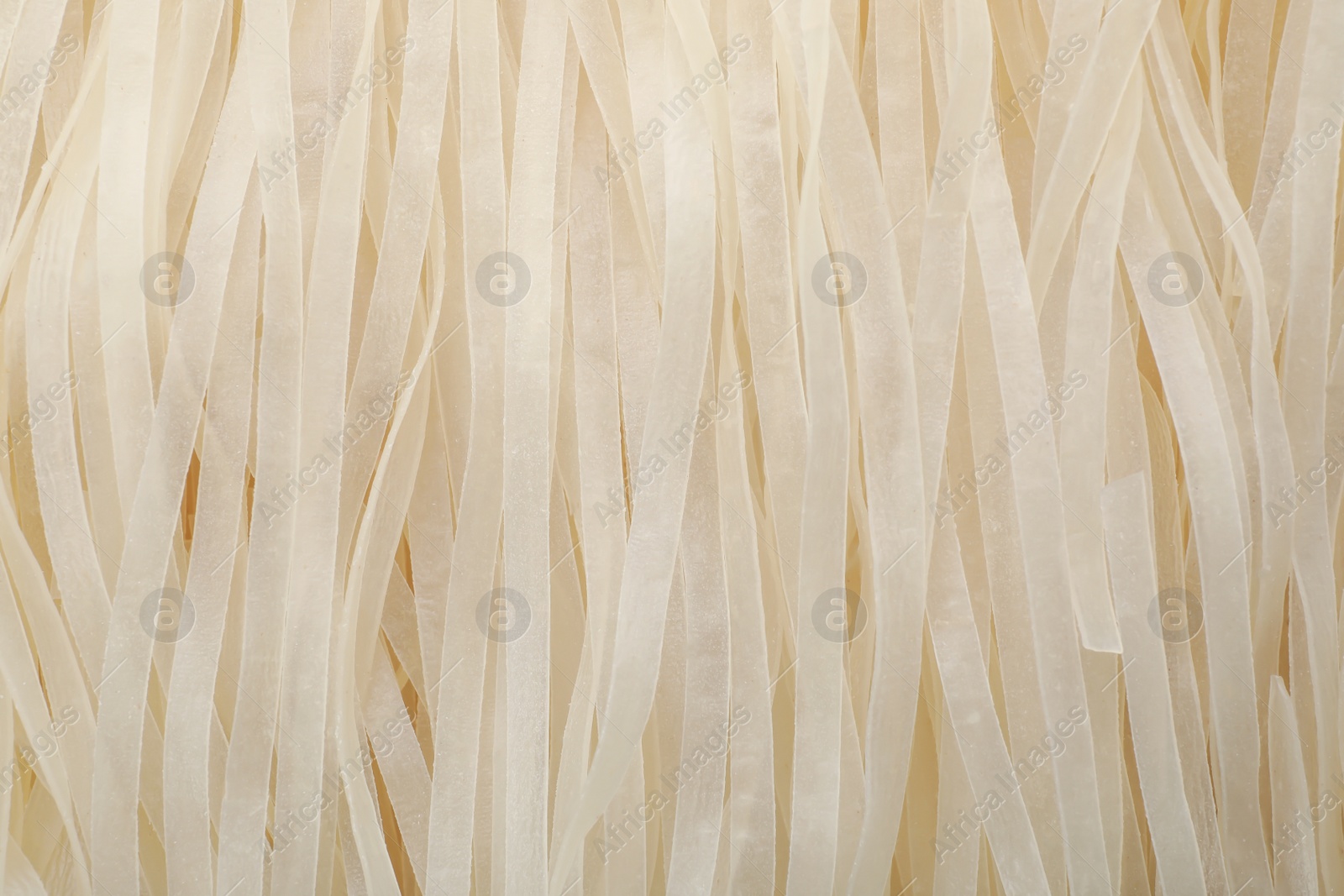 Photo of Raw rice noodles as background, closeup. Delicious pasta