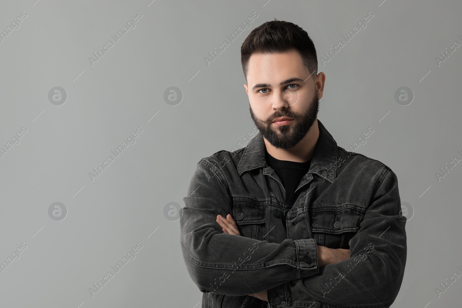 Photo of Portrait of young man with mustache on grey background. Space for text